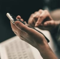 Close-up of a person using a smartphone during an online telehealth nutrition consultation with a registered dietitian for weight loss coaching, personalized meal planning, and insurance-accepted virtual nutrition services. Book appointment.